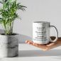 Preview: Hand hält Tasse „Du bist genug“ neben einer Pflanze